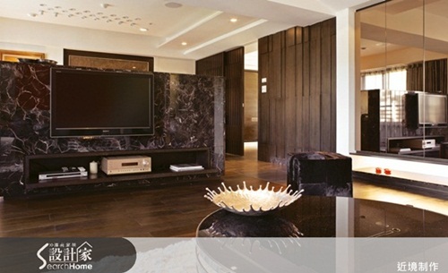 電視牆以黑色大理石與不鏽鋼框架構成，藉由石材與不鏽