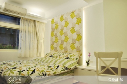 客廳空間的色調除了使用綠色沙發組，電視牆也運用木紋