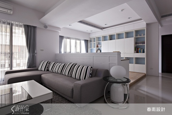 以大面積的白色天花板與白色壁面，搭配客廳藍色電視主