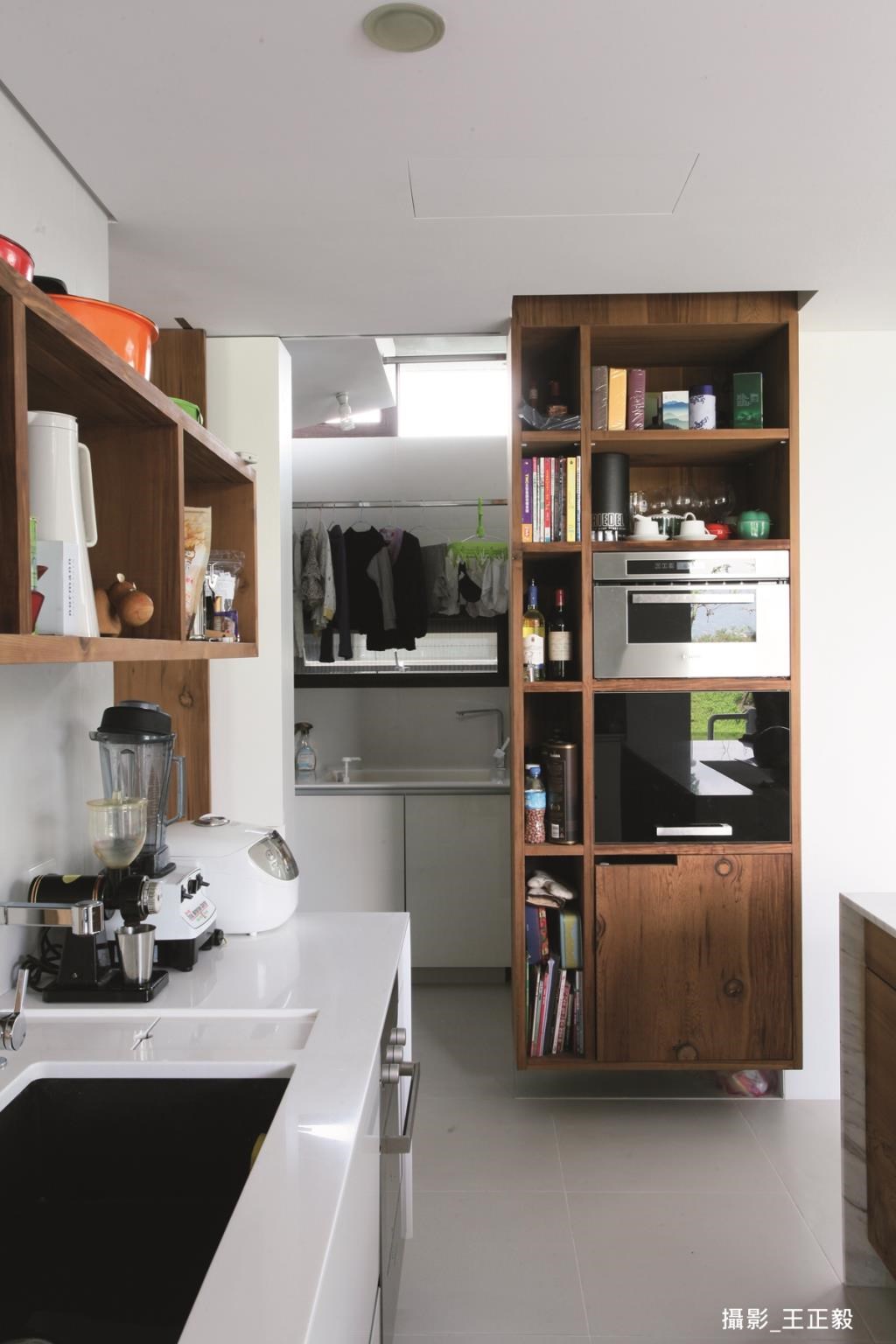 廚房的開放式規劃，讓杯盤、鍋具和調味品成為居家裝飾品，一旁則規劃室內曬衣室，配合拉門設計，藏於無形。