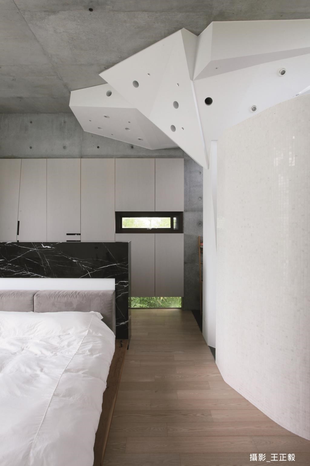 2 樓主臥設計將衛浴空間用一道弧牆做分隔，帶來圓滑視覺感；收納衣服雜物的大衣櫥則採取嵌入式手法，減低視覺深度。