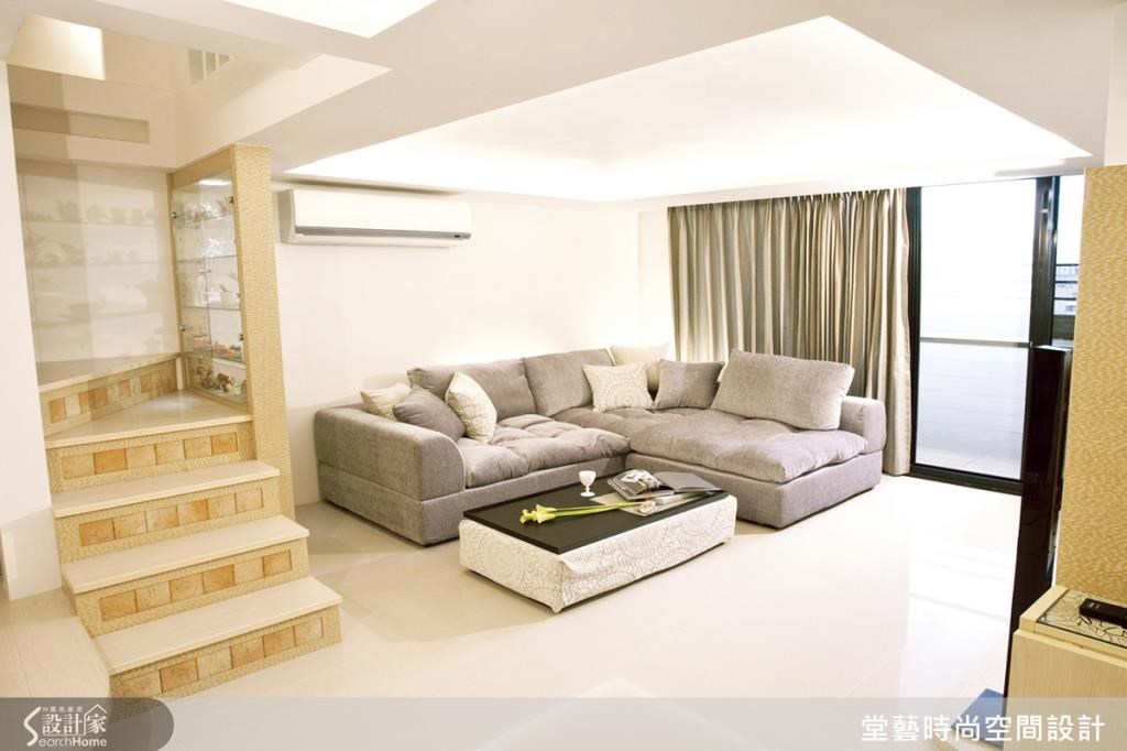 客廳空間擁有充足的採光,和樓梯間以玻璃櫃區隔,兼具空間區分和展示的機能。 客廳空間擁有充足的採光,和樓梯間以玻璃櫃區隔,兼具空間區分和展示的機能。