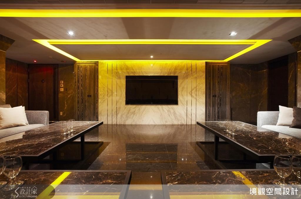 電視牆採用大理石嵌鑲金屬直線條，一方面利用直線條拉長視覺，二方面又利用金屬感消弭整片大理石的單調感；兩旁更特意採取直立的木紋裝飾，更呼應拉高視覺的手法，整體裝潢炫目卻又不流於俗麗。