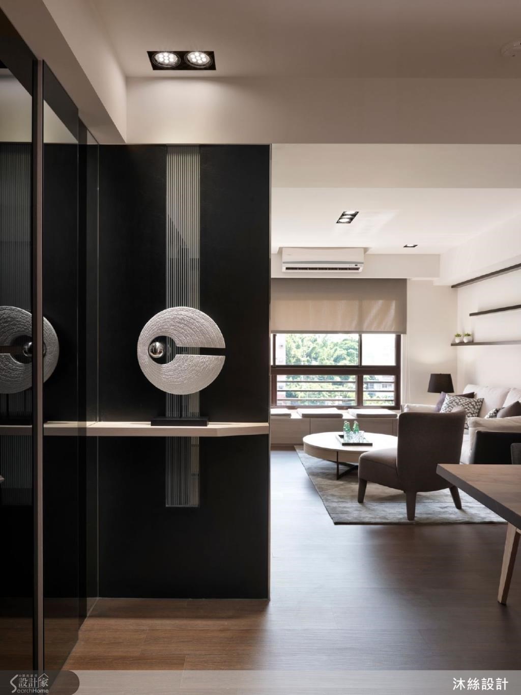 深色鏡面牆以亮面不鏽鋼收邊，透過金屬材質勾勒出立體效果，同時點綴溫潤木紋材質，增添輕盈感。