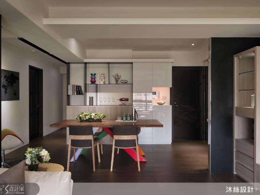 為迎合女主人俐落大方的個性，餐廳旁的端景櫃採「蒙德里安風格」，透過直線、直角、三原色做出剛柔並濟的設計，透過溫潤木質調、白色亮面感、陽剛黑鐵件做出異材質的美感搭配。