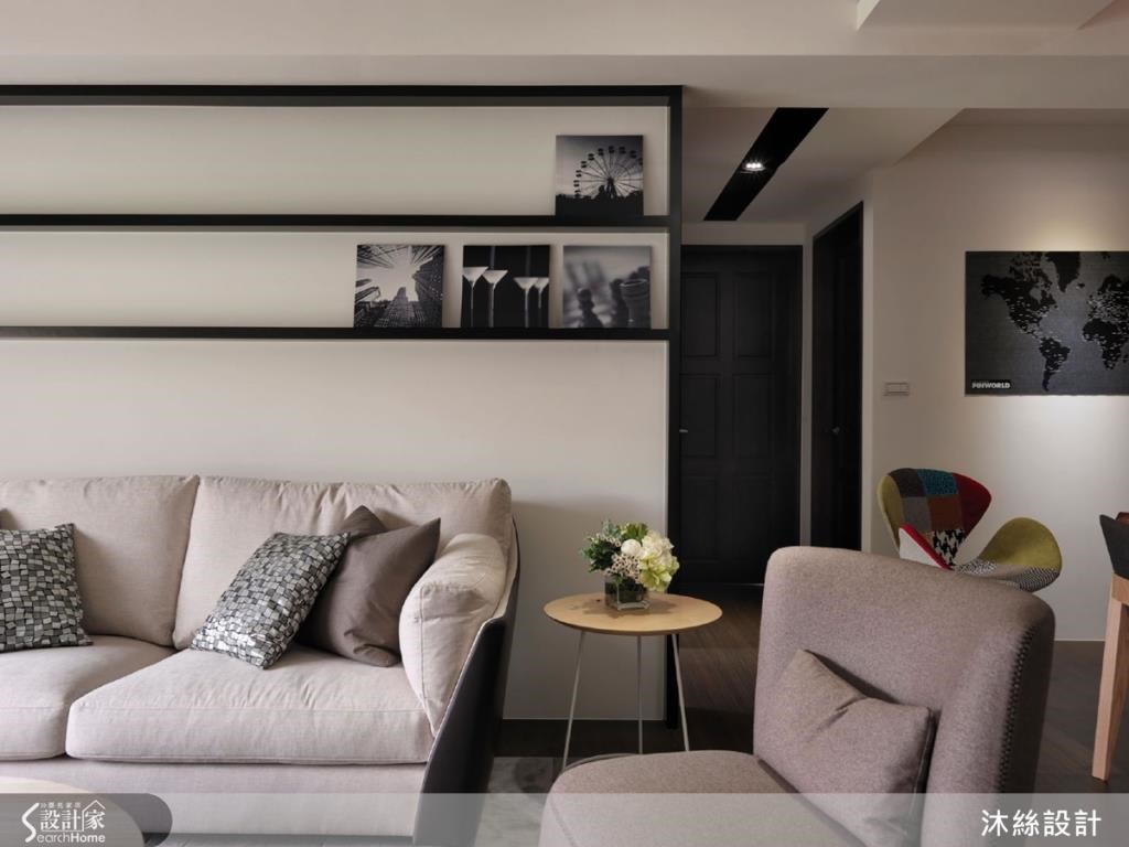 沙發背牆以層板作為裝飾，兼具造型與展示功能，可放上相框植栽，增添生活情趣。俐落的黑色線條將藝術融於設計。