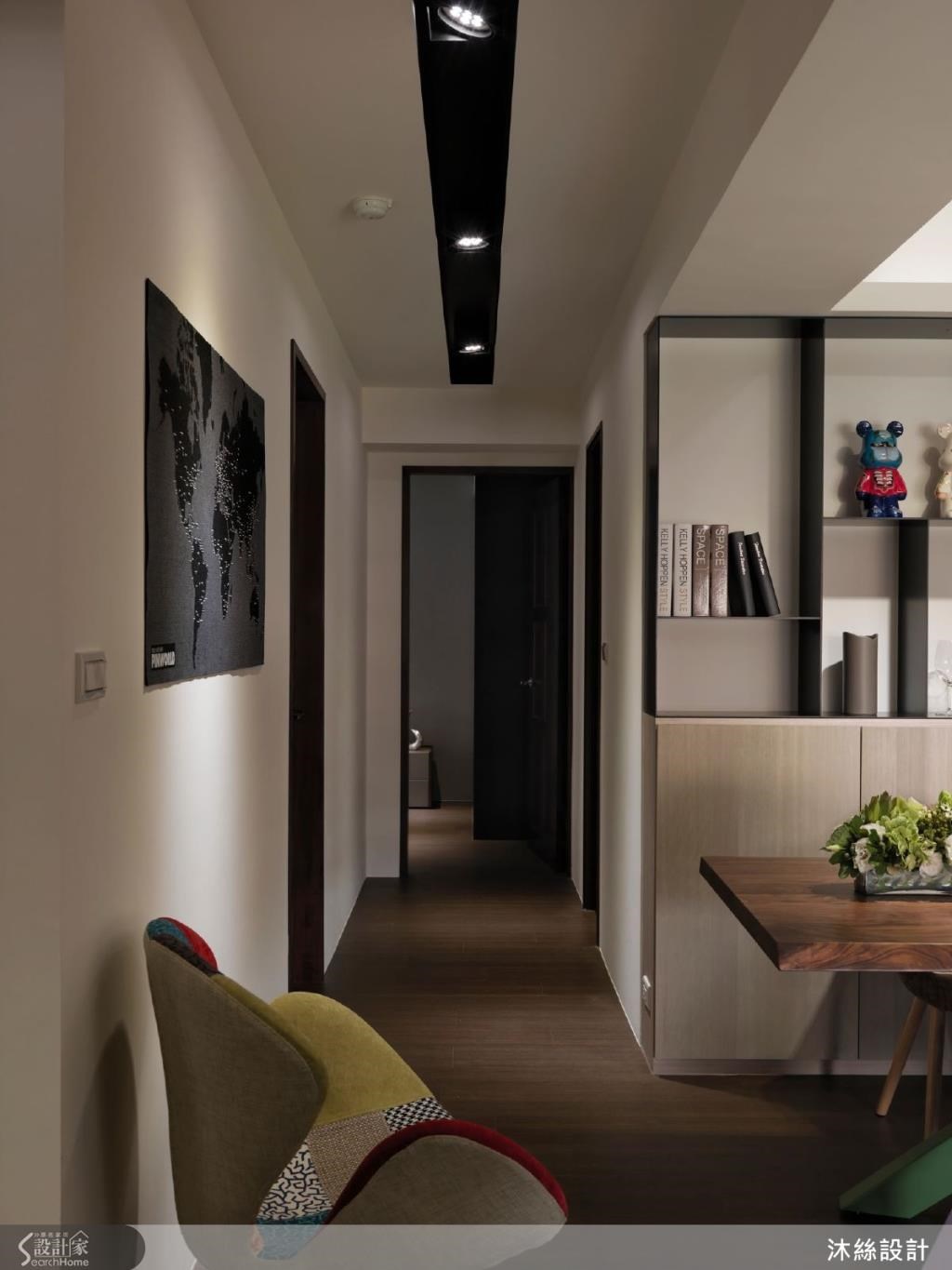 廊道呼應空間的黑色線條，採黑色燈溝設計，指引公領域走進私領域的動線，延伸空間感；並在牆面採用投射燈重點照明，做出牆面上的視覺焦點。