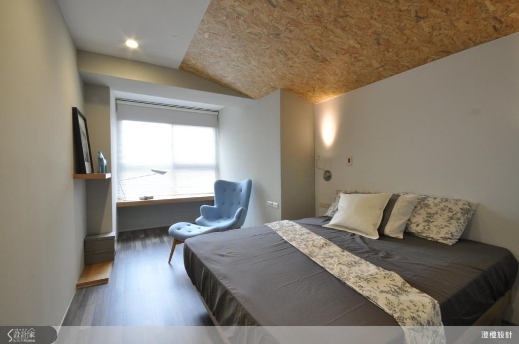 主臥室以定向纖維板構成斜面來修飾大樑，同時也創造出一種閣樓斜屋頂的視覺趣味。