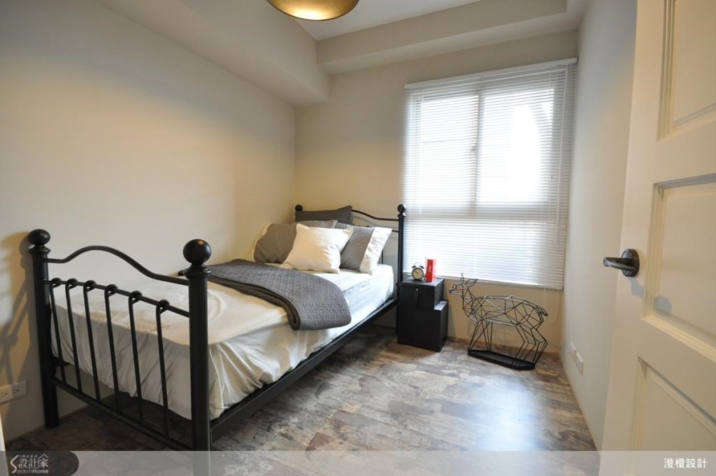 次臥以帶有刷舊紋理的木質地板鋪陳空間，搭配黑色鐵件床架，帶來一種懷舊又浪漫的復古調性