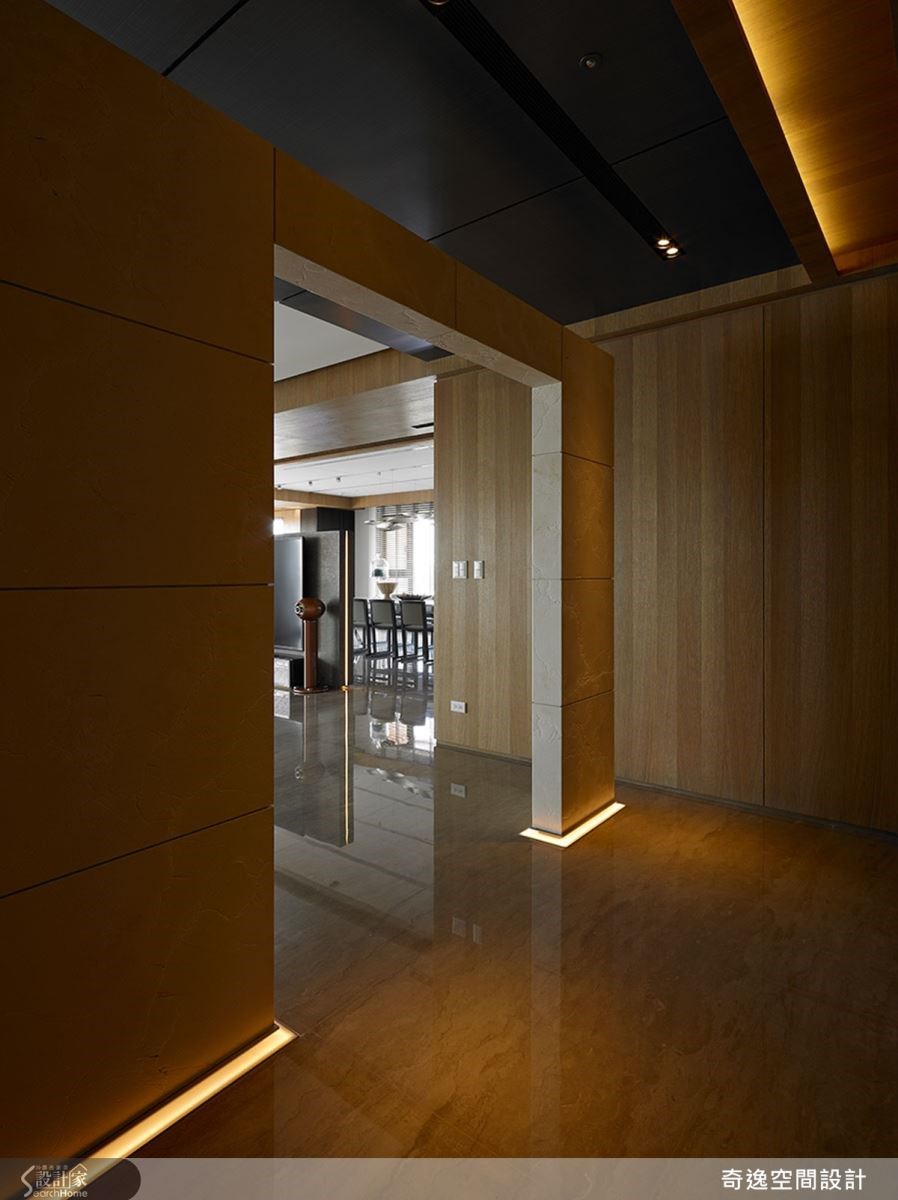 一進門的玄關處，設計師刻意以一道不做滿的牆面，化解風水上穿堂煞的問題，同時也成了不讓人一眼看穿室內空間的精巧設計；木皮特別選用漆料，並以自然推油手法，打造環保與質樸空間。