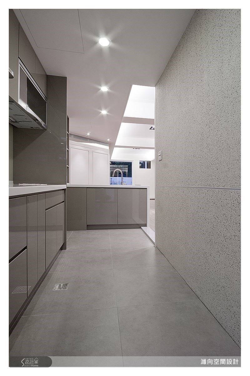 洗石子壁面,勾勒出手感的氛圍,貼近餐廚空間的核心概念,淺咖啡灰色的烤漆廚具,烘托出內斂且沉穩的氣息,再以中島吧檯區隔餐廚空間,使廚房成為美感的食尚空間。 洗石子壁面,勾勒出手感的氛圍,貼近餐廚空間的核心概念,淺咖啡灰色的烤漆廚具,烘托出內斂且沉穩的氣息,再以中島吧檯區隔餐廚空間,使廚房成為美感的食尚空間。