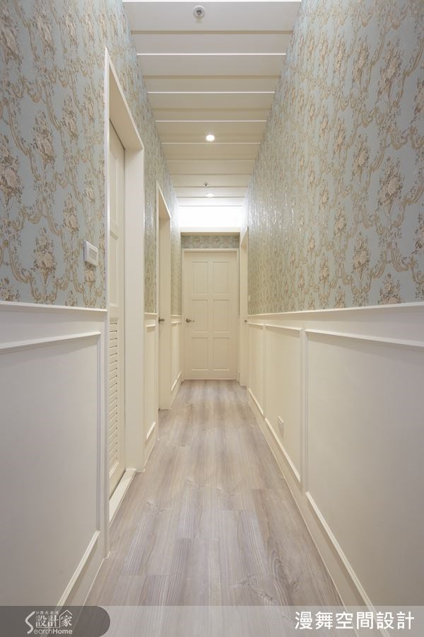 走道搭配跳色的圖騰壁紙，天花板與走道兩側(腰帶)也設計線板造型，讓純白空間變得更有層次。