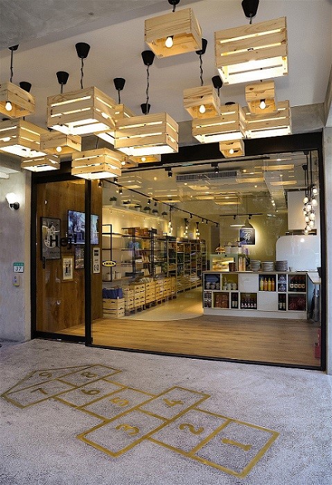 創意利用 KNAGGLIG 儲物盒，巧妙變化成入口處天花板裝飾燈，特殊造型搭配台灣傳統磨石子地板及台灣童趣遊戲-跳房子，讓消費者眼睛為之一亮。圖片提供_IKEA