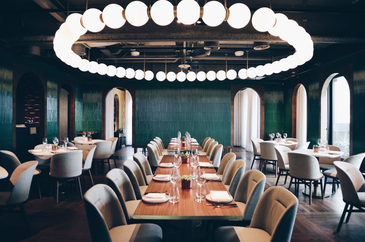 位於 12 樓的 The Tavernist 餐廳，空間中心的圓型燈飾以珍珠項鍊意象，連結新舊時代的時髦經典。