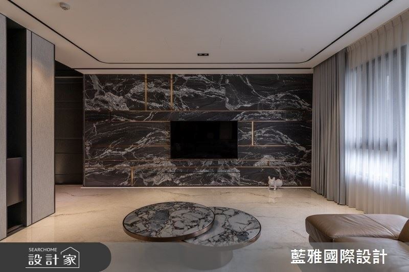 客廳電視牆精選雕刻黑大理石，挹注潑墨山水意象。