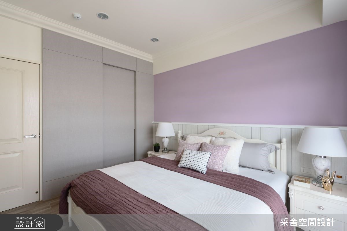 主臥床頭選用女主人喜好的紫色系做搭配，並加入淺色木紋質感點綴，型塑柔和舒適的美式浪漫氛圍。