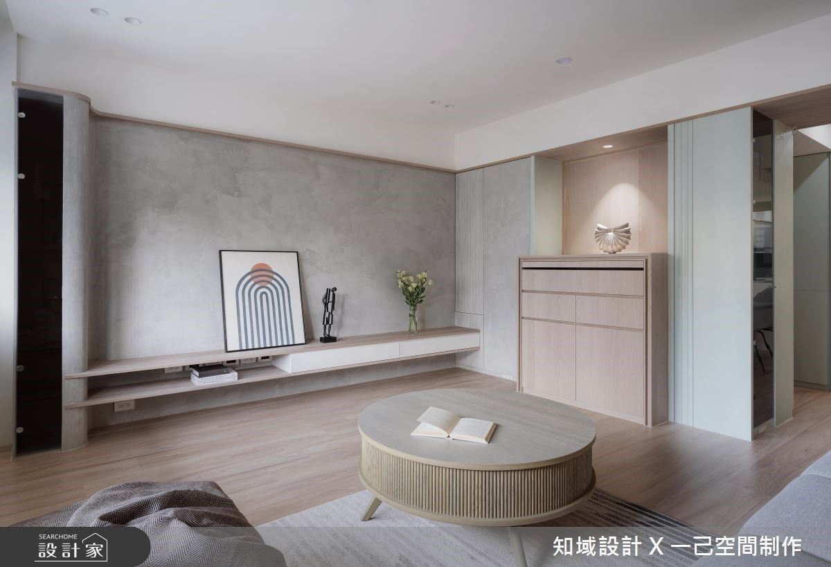 電視牆左邊整合機櫃，透過材料延續營造一體成型的視覺感受。