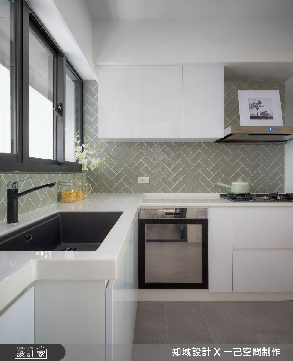 廚房以白色櫃體搭配綠色鐵道磚，延續低彩度設計呼應整體清爽北歐調性。