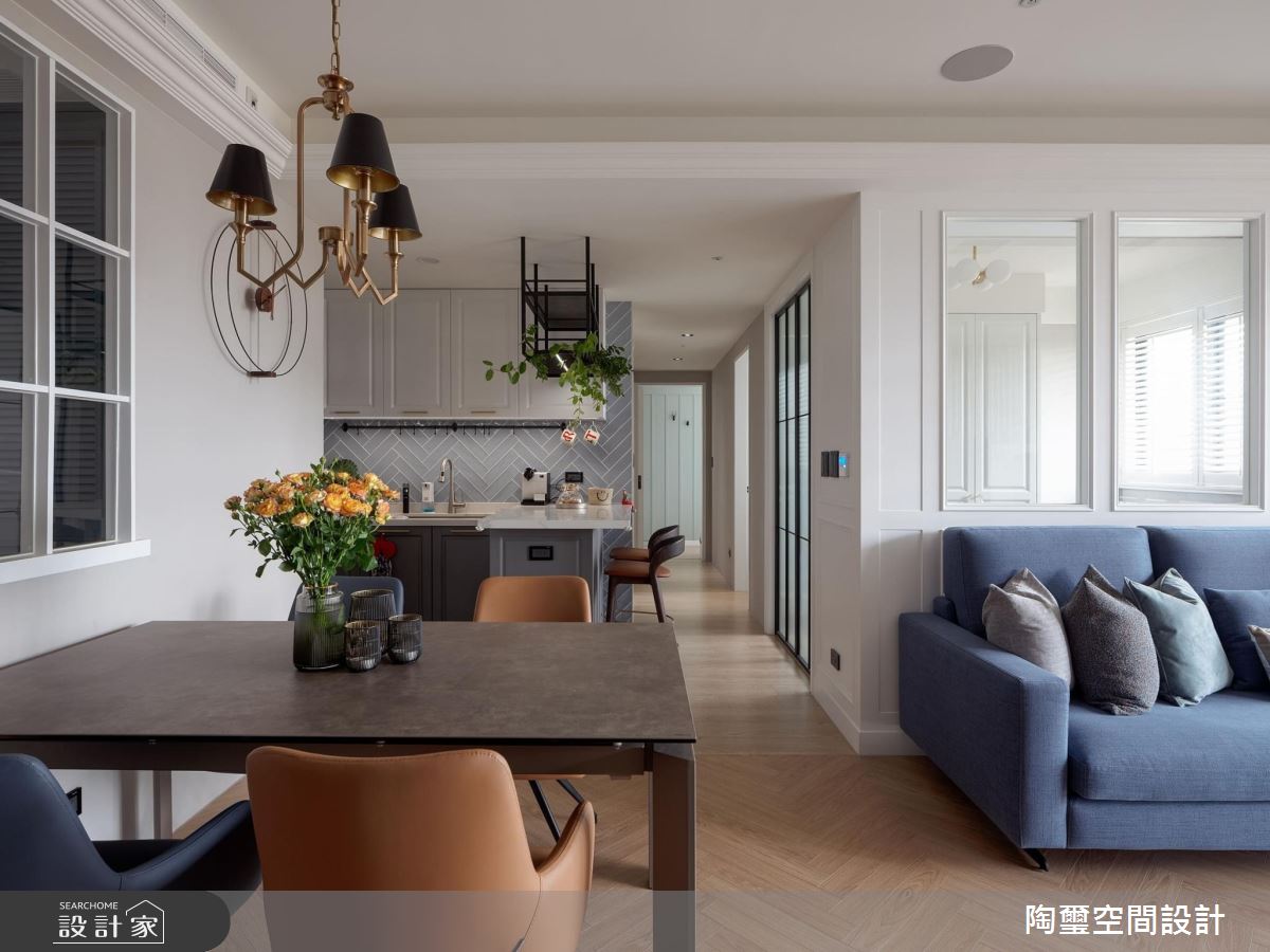 小家庭餐桌透過格柵窗與玄關落塵做出半開放式的間隔，同時與廚房、廊道砌成一線，各空間的領域性能自然脫穎而出。陶板桌面與鐵件桌腳以及古銅金吊燈，低調有質感，把屋主喜愛的鐵件元素巧妙融入於各空間之中。