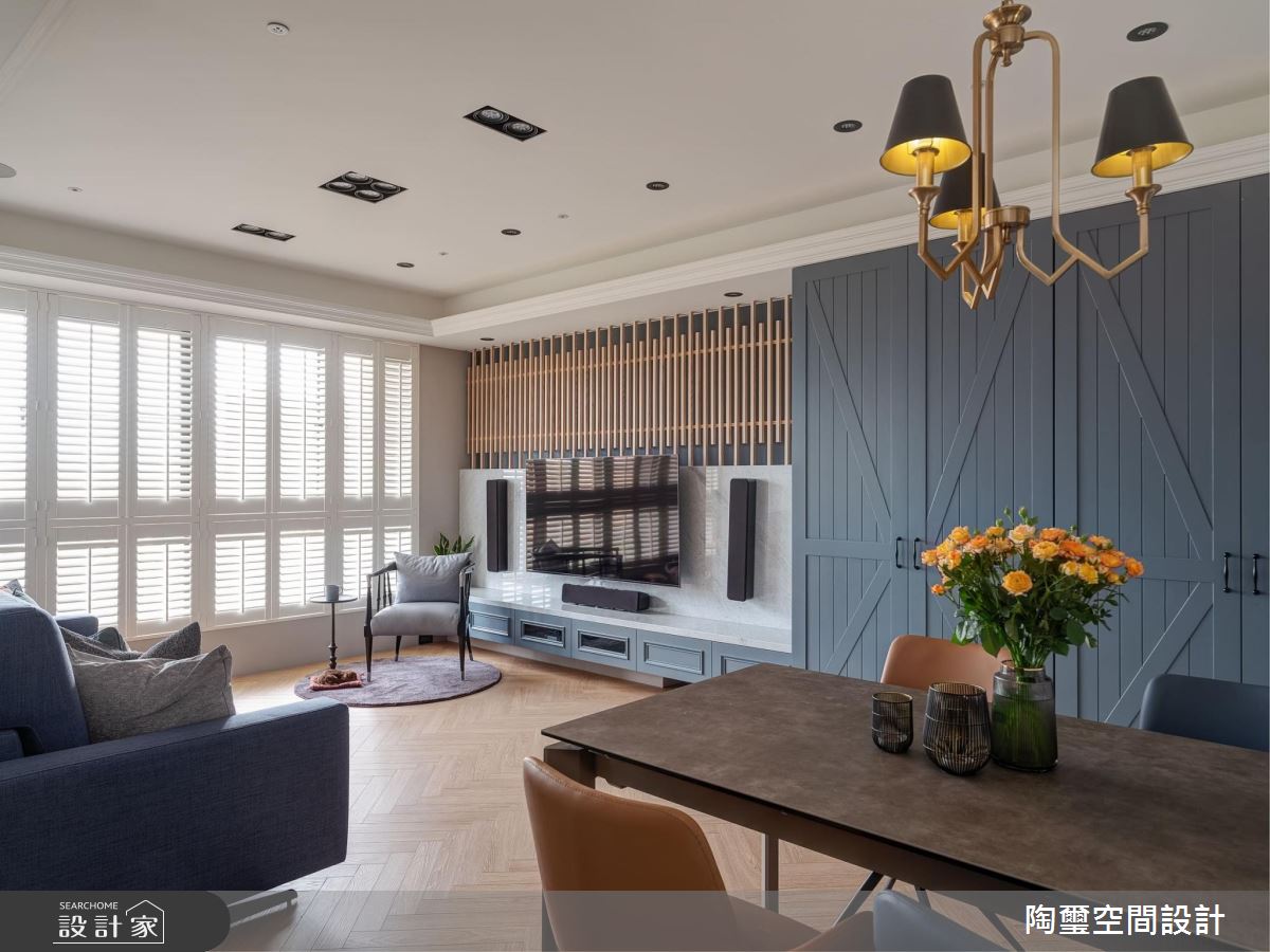 黑底木紋格柵佐以大理石的電視牆，直接帶出室內的主視覺，木紋的潤與暖平衡大理石的硬與冷，既個性又溫馨，視聽櫃的深度與穀倉門切齊，保有視覺順暢且增加多的收納空間。