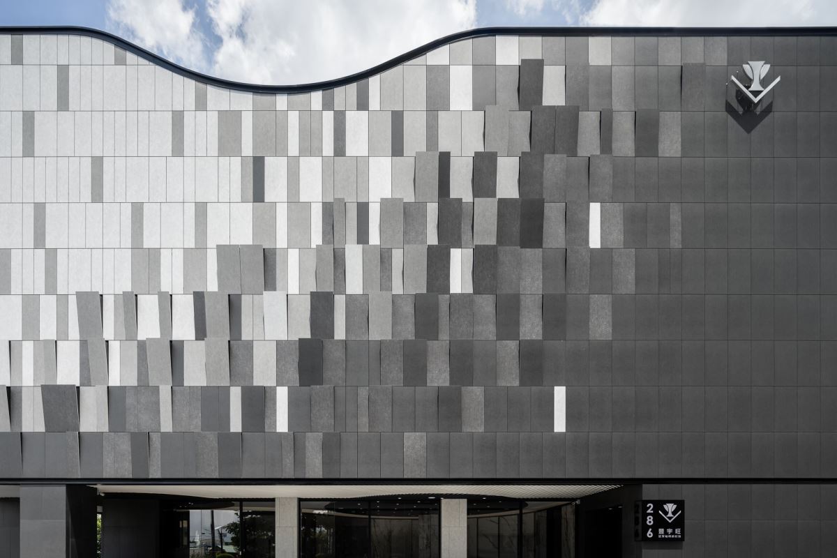 建築師巧手，透過深淺漸層的再生綠建材磁磚結合不同立面角度，在轉角處創造出柔美 Ｖ 字形曲線的品牌識別符碼，讓品牌與建築巧妙地合而為一，成為台中最新地標！