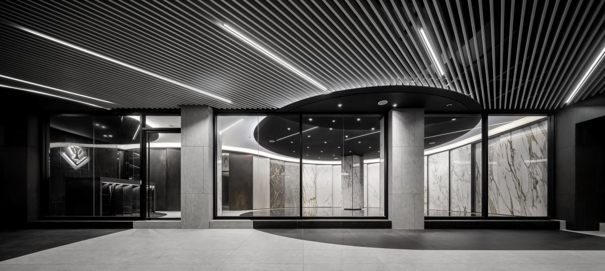 綠建材外牆磁磚向下延伸至騎樓櫥窗由室外轉入室內，完整流暢的線條，形塑室內外融合空間美學。