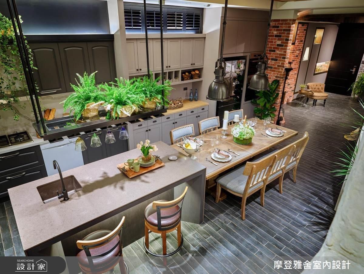 開放式餐廚空間,劃整電器櫃位置,與烹調洗滌中間增加備菜工作檯面,牆面上下鄉村風收納櫃滿足使用需求,將餐具杯盤分門別類收納,更不放過挑高空間,建構鐵件吊櫃可以展示收藏水晶杯亦有綠植點綴空間,讓開放式餐廳、廚房與客廳充滿生機與異國氛圍,滿足常旅行各國的異國夫妻屋主的生活逸趣。