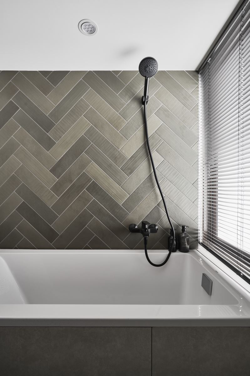 為了讓浴室體現出清爽的質感,挑選比較亮色的人字拼壁磚來表現。