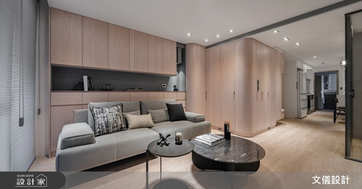 沙發背牆櫃體留白一隅，運用灰色霧面漆來搭配燈光，讓屋主可以展示收藏品，上下區域則能靈活分配收納需求。