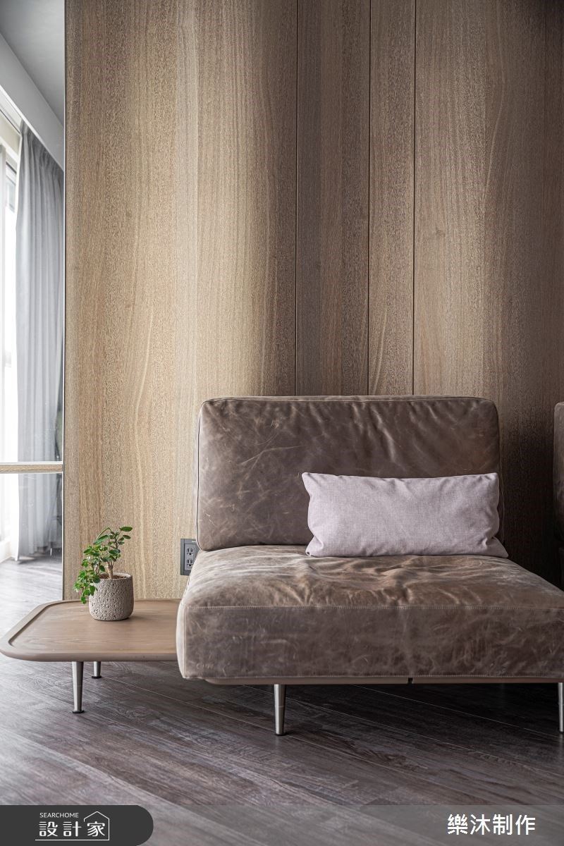 沙發背牆靠窗位置，延伸局部的玻璃牆，減少空間上所造成的壓迫，並增加穿透度，在視覺感受上更為寬闊，同時也讓夫妻倆在各空間活動時，能產生出內外的互動性。