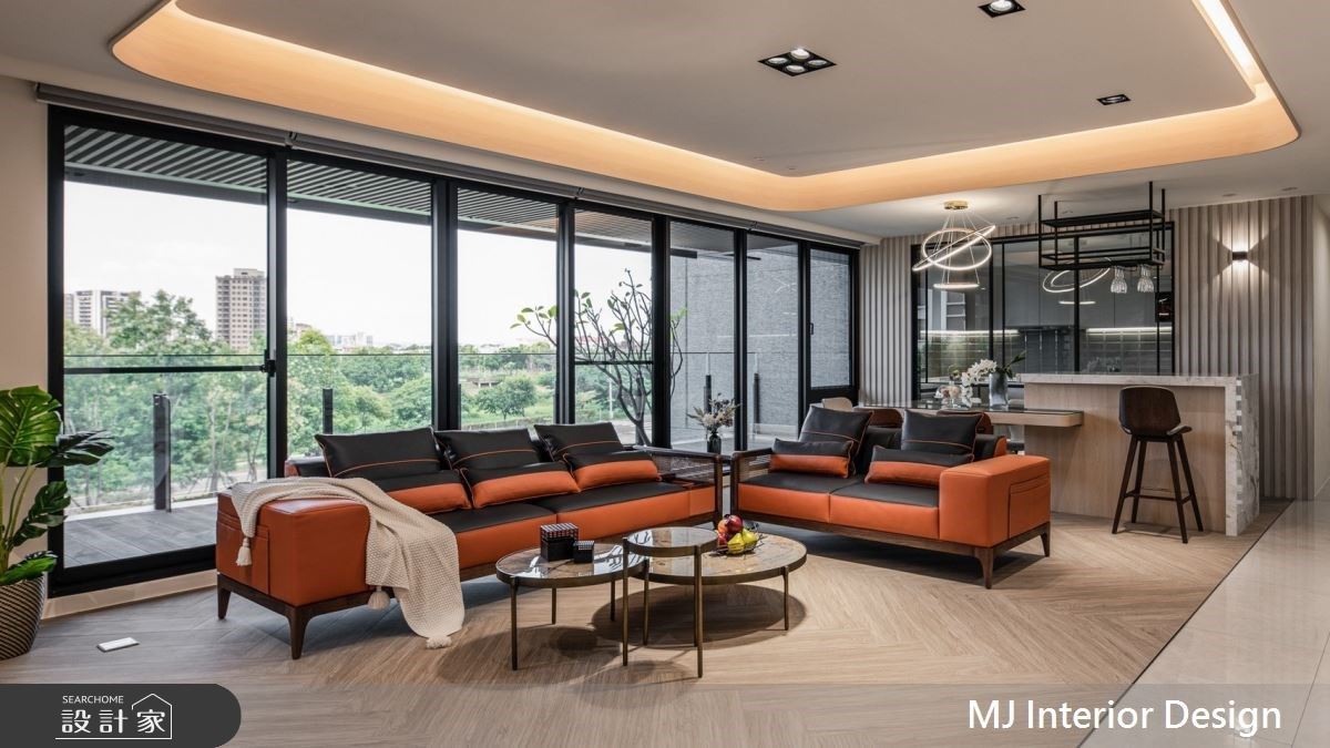 家具選擇亮橘色和墨藍色交錯的時髦皮沙發和俐落鐵件線條,與窗外的樹影綠景產生時尚與自然的美學對比。