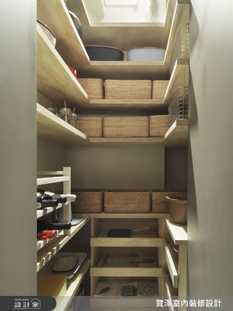 在餐廚區儲藏室中，不常使用的大型鍋具規劃於上層空間，並利用分類籃彈性收納乾糧和廚房備品，紅酒收藏則放置在容易拿取的高度，減少不小心打破的可能性。》看更多案例圖片