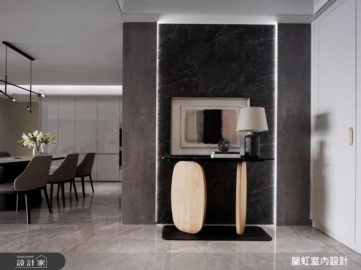 玄關端景牆面使用仿石紋的板材,再利用燈條框出引人入勝的牆面,提升迎賓效果,同時也引導著進屋動線。