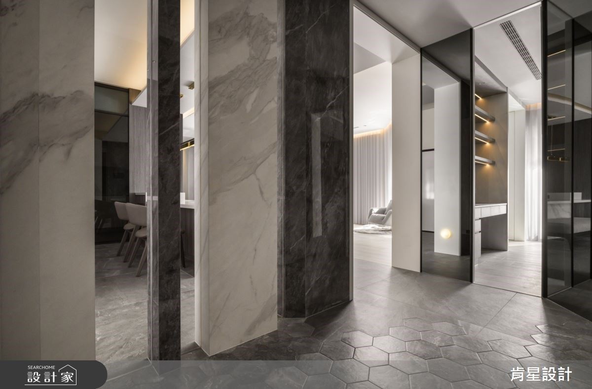 玄關地板採用灰紋六角磚拼貼,左側大理石磚隔屏中嵌入玻璃,使玄關空間保有通透。