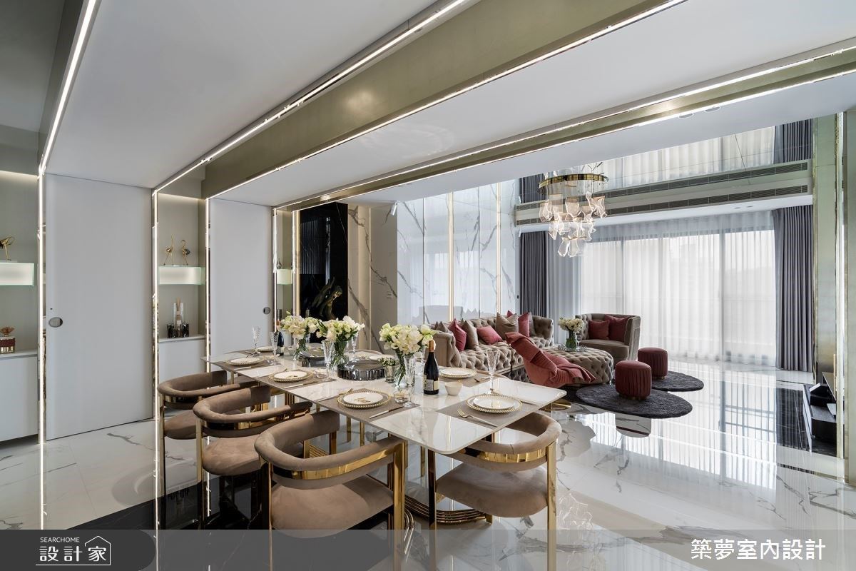 餐廳區結合鈦金屬和燈帶材質，並在天花板利用時尚俐落的 ㄇ 型包覆，不僅整合私領域和廚房動線，也增加收納和展示效益。