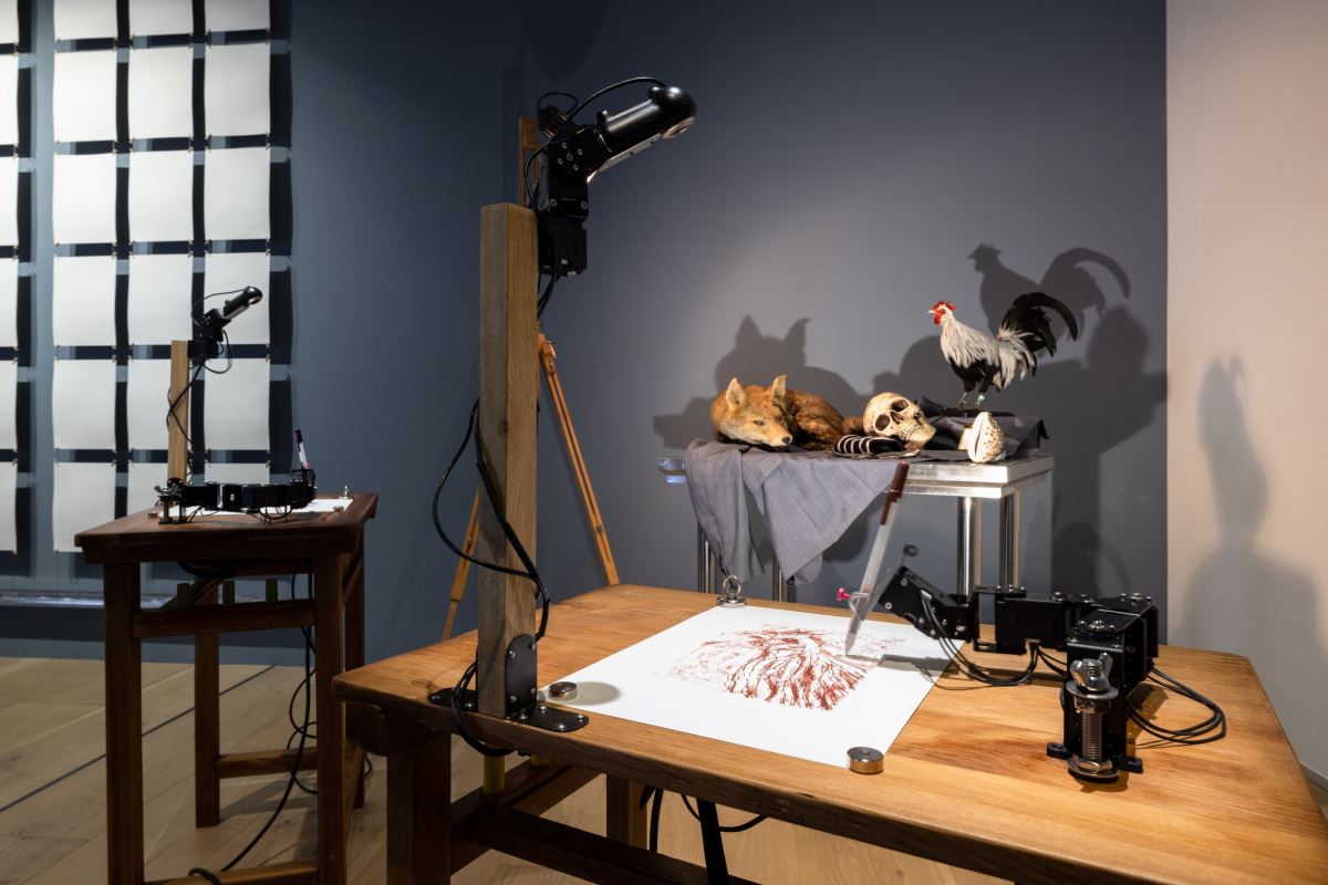 法國藝術家Patrick Tresset〈人類研究#2─公雞與狐狸等的大虛幻〉中機器手臂進行素描繪圖,也由此行為反思機器的「創作」是否為創作 ©忠泰美術館