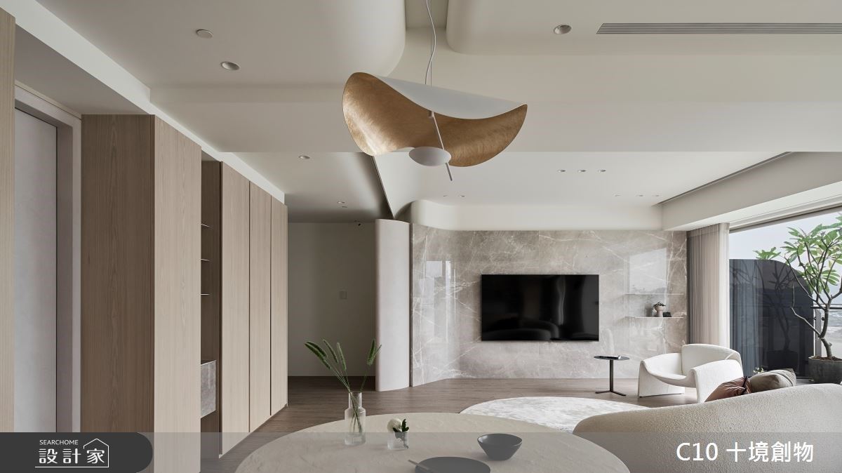 客廳大理石電視牆表現原始紋理,呼應窗外的自然景觀,同時天花樑柱以弧形線條描繪,除了保留原始屋高,也修飾原先錯位樑柱的銳利,展現優雅感受。