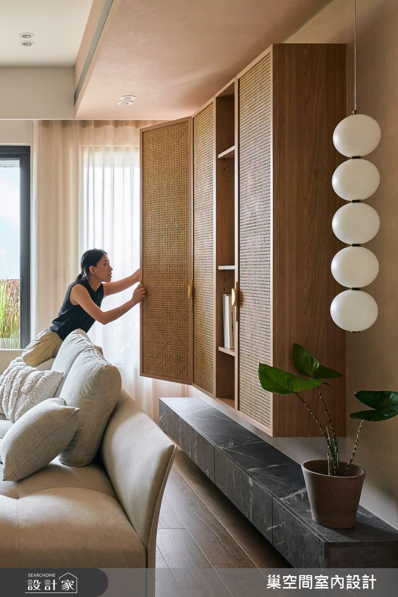 沙發背牆設計上下懸空的藤編收納櫃,呼應前方電視主牆的呈現,體現空間留白的重要性,堆疊空間的呼吸感,傳達放鬆自在的精神。