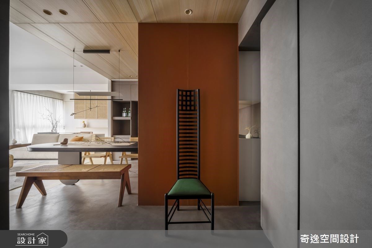 玄關到餐廚運用深咖啡色塗料圍塑空間場域,立面則選用亮橘色皮革,營造入門質樸感的端景。