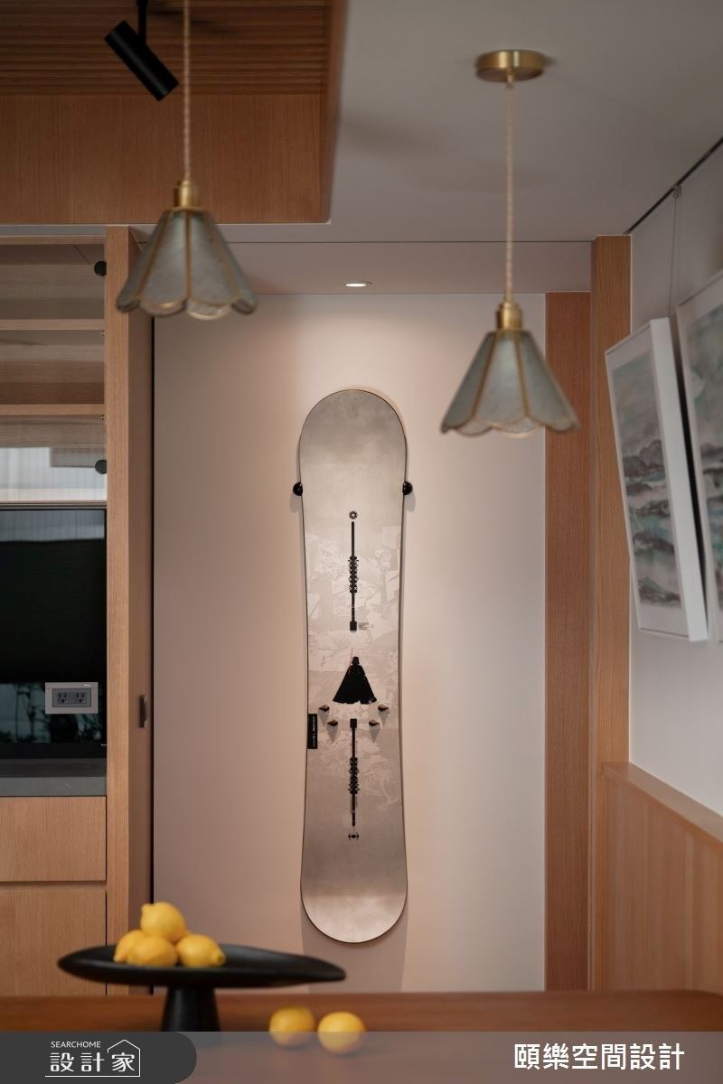 突兀的樑柱產生畸零角落，設計師劃分儲物間，並在出入口擺放屋主的滑雪板，作為端景牆，不僅完善利用坪效，更象徵滑雪愛好的精神。