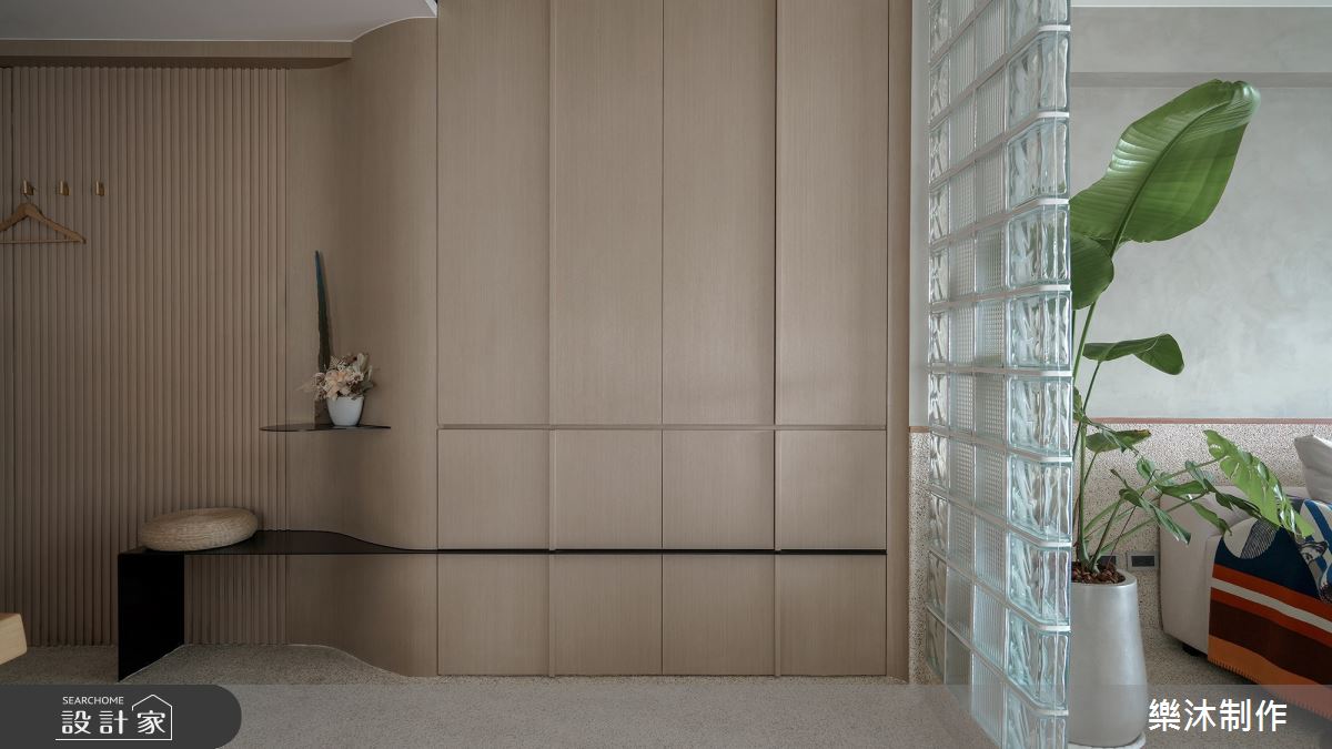 為配合開闊的空間感與水岸環境,設計師在玄關一路延伸至客廳的背牆,搭配玻璃磚與抿石子,打造新舊材質並存的復古美感。