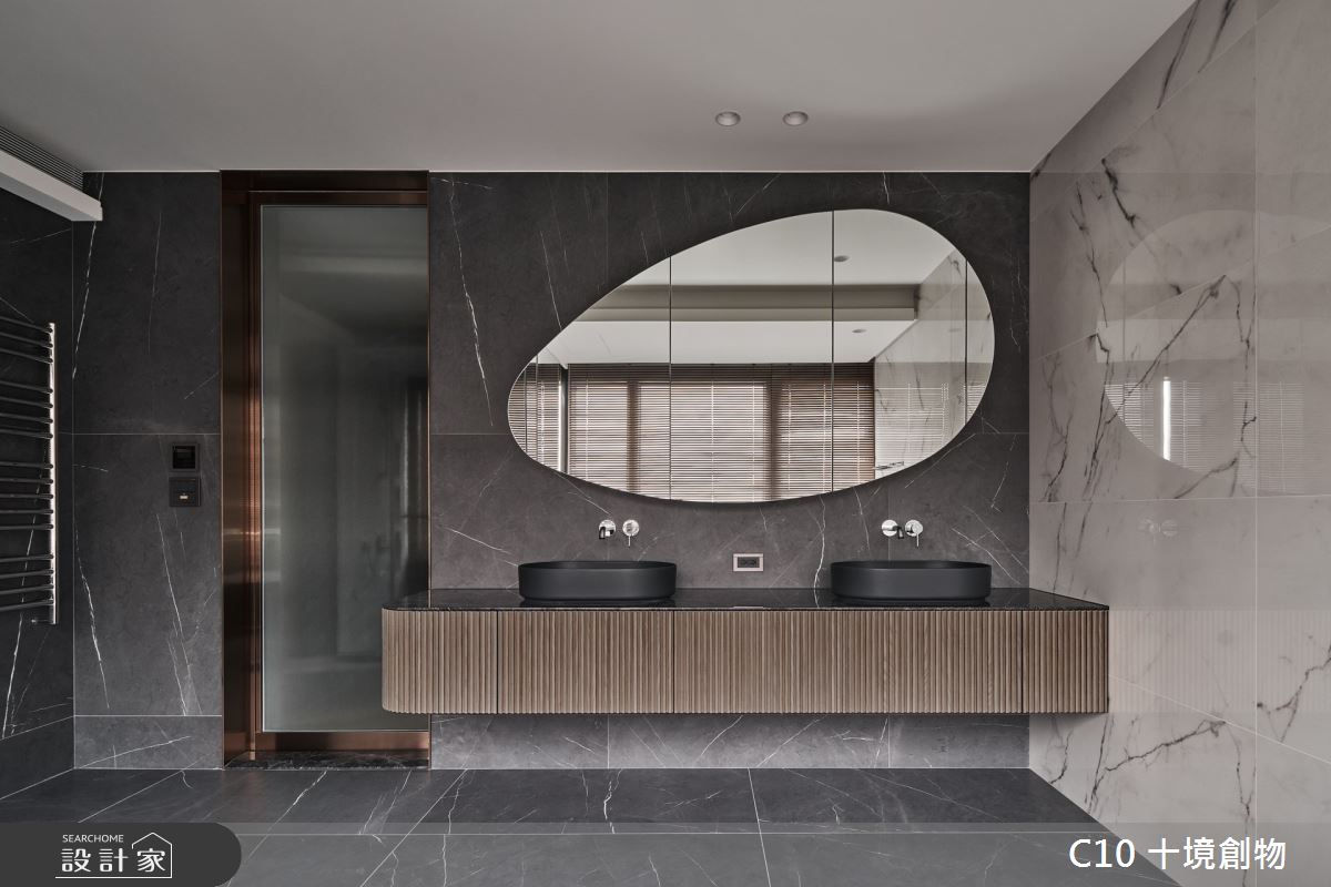 蛋形鏡櫃搭配雙面盆的黑色石材結合木格柵浴櫃,下方懸空的間接照明光線,強化空間精緻感。