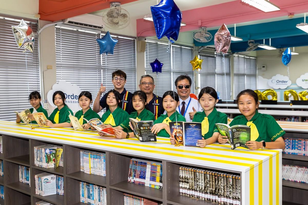 在充滿童趣的信勢國小第52所歐德幸福圖書室,左起黃昱豪設計師、江衍欣總經理、校長曾德鴻與孩子開心合影。