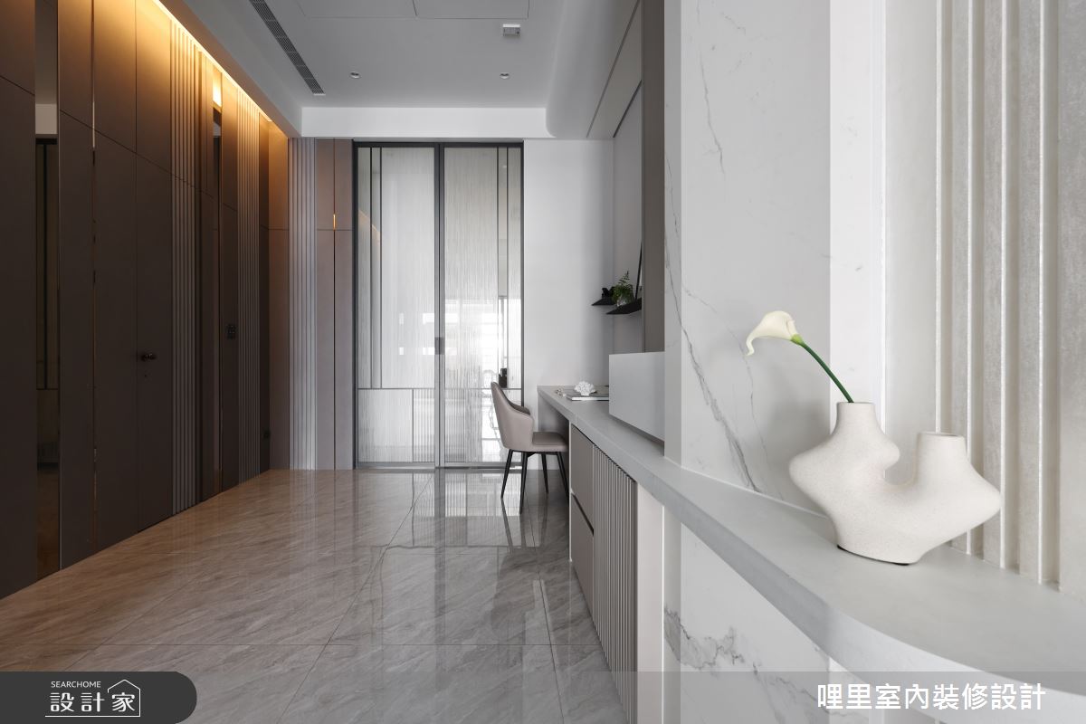 非對稱的造型包覆原先突兀柱體,加入板磚、線條、燈光,美化樑柱,將它隱身在內。