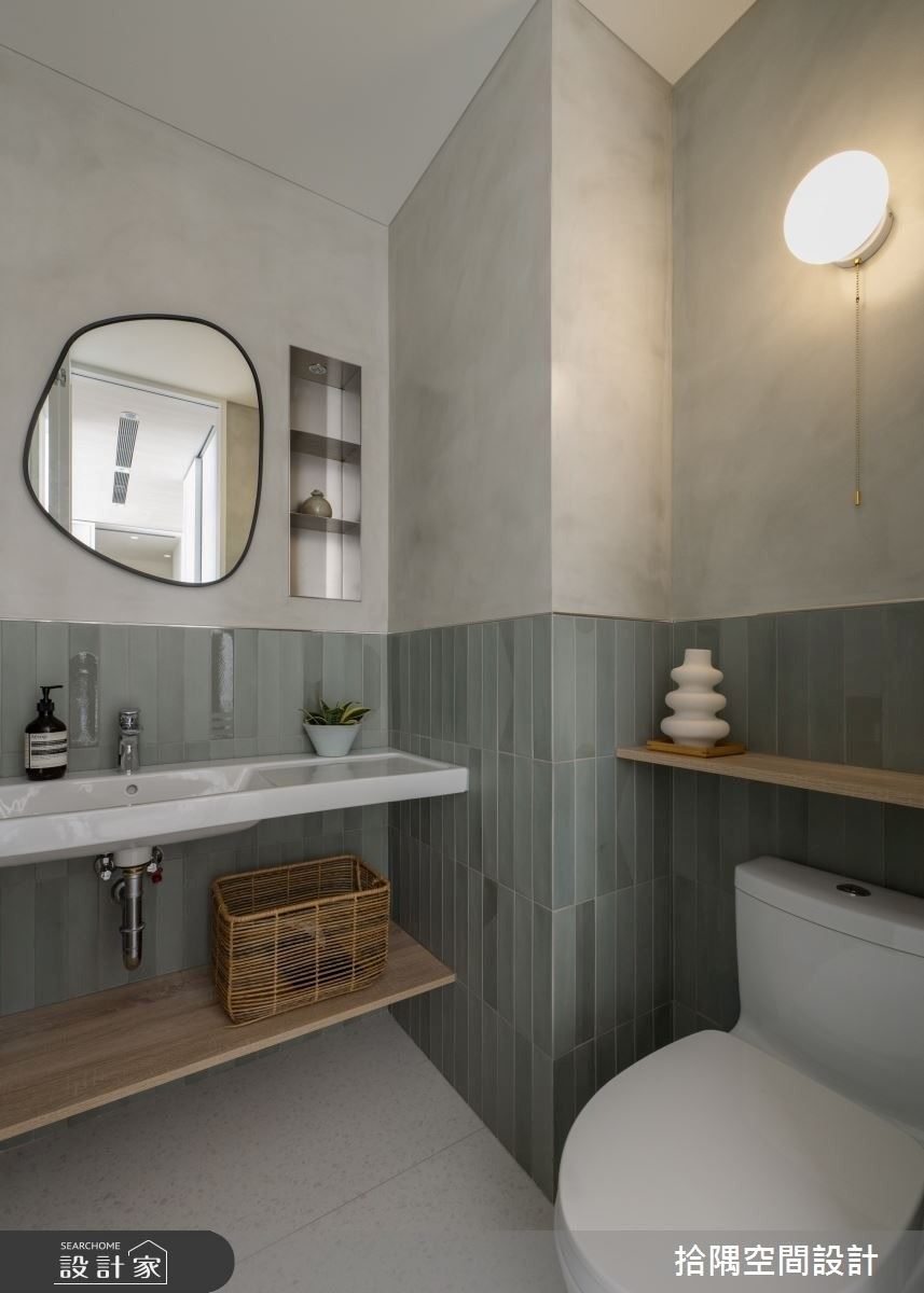 客廁採用玻璃折門設計，提升空間通透感，搭配灰色塗料與手工窯變磚，營造清爽質感。
