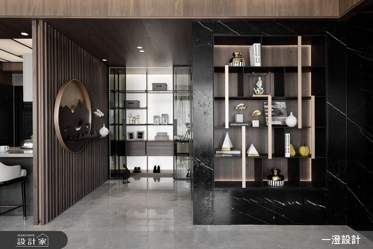 深色石材與金屬線條讓玄關成為藝術端景，並結合鞋櫃與展示層架，營造儀式感與機能性皆充足的層次感玄關。
