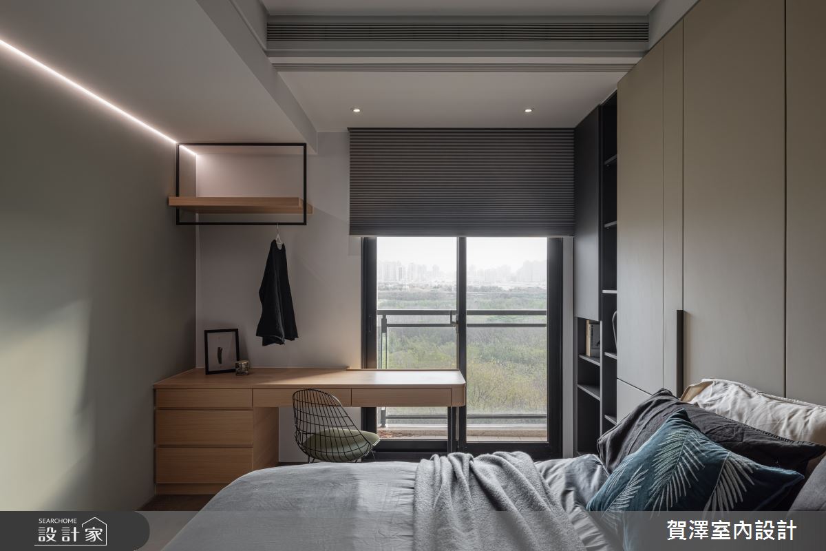 男主人偏好綠色調，設計師便以沉穩的灰綠色鋪陳男主臥牆面，機能面則提供充足衣物收納，書桌上方另設開放吊掛架，方便擺放穿過但未清洗的衣物，兼顧實用與生活習慣。