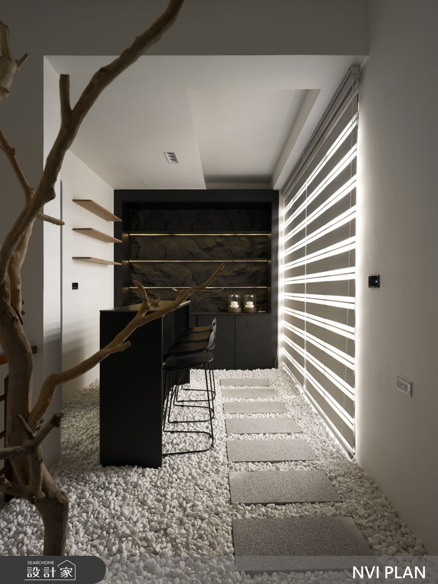 頂樓則是一處極具休閒氛圍的位置,設計師善於空餘空間,鋪上鵝軟石地面與黑色吧檯,呈現家中獨享的空中花園。