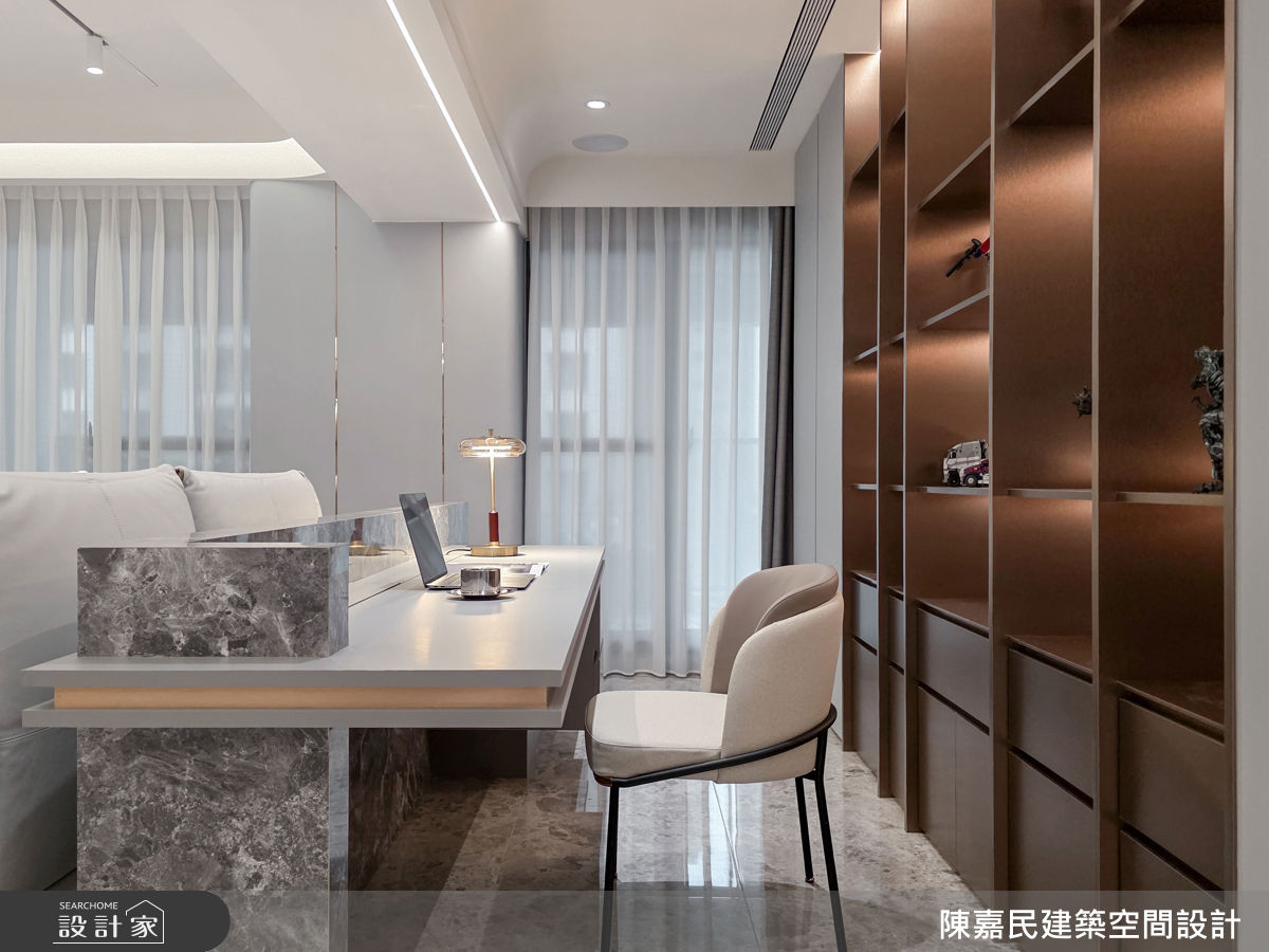 開放式書房採取半腰桌面設計，與客廳相連無隔間，後方展示櫃成為第二主牆，擺放屋主收藏，增添視覺亮點。