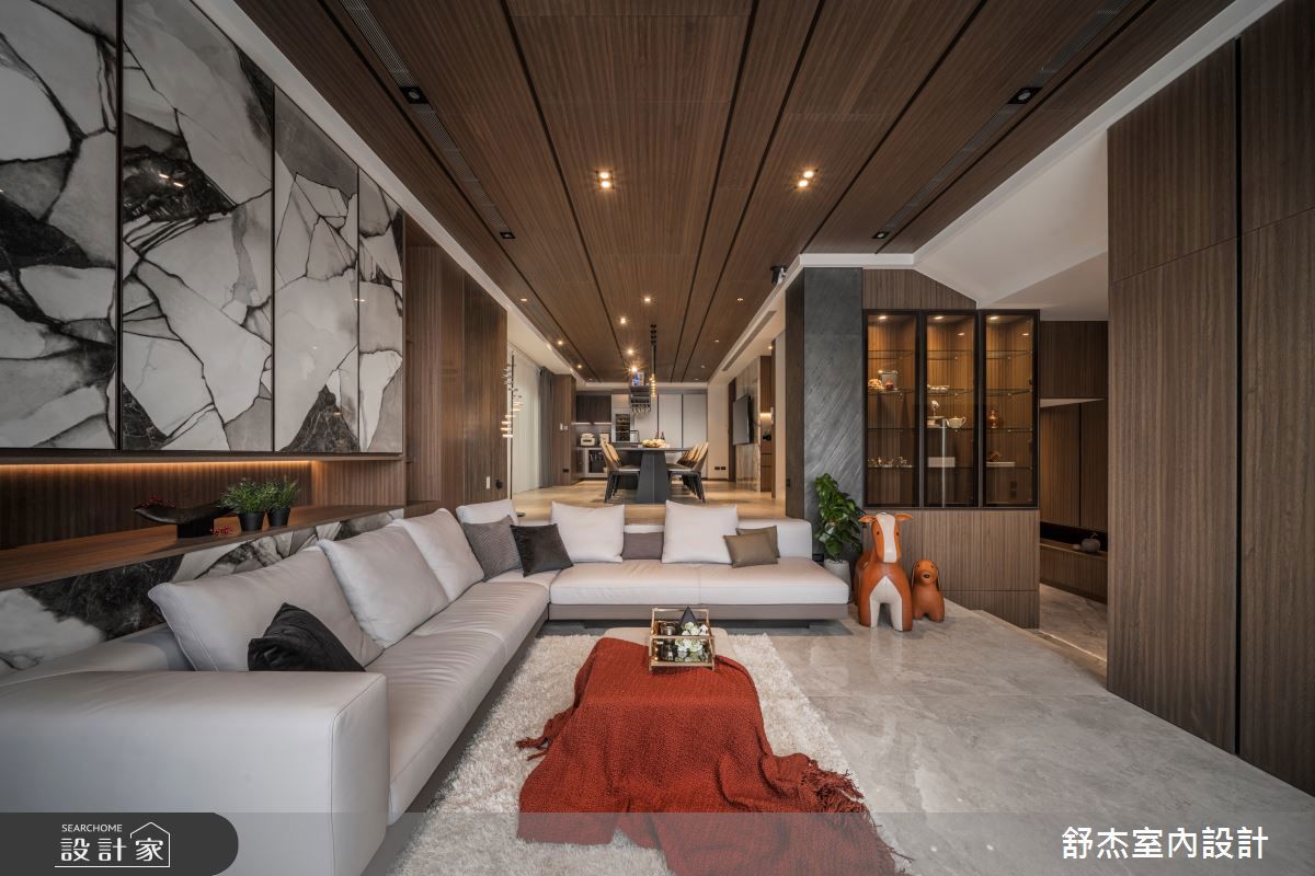 沙發背牆以木質嵌入天然大理石，讓收納櫃體不再單調，化為客廳的異材質藝術品，大器而實用